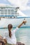 Woman waving hand goodbye at cruise ship leaving. Caribbean luxury travel vacation concept. Boat port of call harbor, people