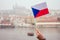 Woman wawing with Chezh flag in Charles Bridge and making a wish touching the bronze plaque bridge for good luck