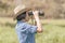 Woman wear hat and hold binocular in grass field