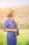 Woman wear hat and hold binocular in grass field