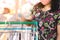 Woman wear mask using alcohol nano mist sprayer antiseptic cleaning on shopping cart trolley handle protection during Coronavirus
