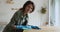 Woman wear protective gloves cleans table smiles looking at camera