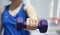 Woman wear sport watch hold lifting dumbbell one hand force lip for breast biceps muscle weight training indoor blur background