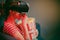 Woman wear VR headset and watch movie with popcorn at night. American woman sitting on the sofa in the VR glasses and