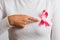 Woman wear white shirt pointing finger to pink breast cancer awareness ribbon