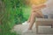 Woman wear white shirt and short jean, her relaxing on wooden chair at outdoor garden surrounded.