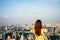 Woman wear yellow dress, Asian traveler standing with their backs turned and looking aside on balcony with beautiful modern big