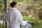 Woman wearing bathrobe against blurred plants