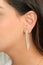 Woman wearing beautiful tennis chain earrings with zirconia