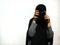 A woman wearing a black cape taking a photo with a white background.  Muslim women.  Asians