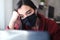 A woman wearing a black mask trying to stay focused while working from home due to Covid-19, struggling with anxiety and depressio