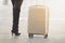 Woman wearing boots standing beside a travel luggage