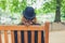 Woman wearing bowler hat in park on bench