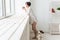 Woman wearing cozy home shirt relaxing at home and playing with dog jack Russell terrier, drinking tea. Morning concept.