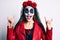 Woman wearing day of the dead costume doing rock and roll gesture with fingers celebrating crazy and amazed for success with open