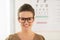 Woman wearing eyeglasses in front of Snellen chart