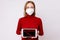 Woman wearing a face mask, showing red arrow moving down, recession process in the economy on digital tablet, Coronavirus pandemic