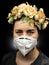 Woman wearing FFP2 mask and flowers on their head representing new hope during coronavirus pandemic