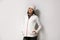 Woman wearing fleece jacket and hat on grey background. Winter sport clothes