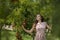 Woman wearing floral long dress against pomegranate trees