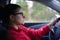 Woman wearing glasses drives car and is concentrated looks at road