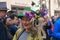 Woman wearing a green bonnet with purple flowers at the Fifth Avenue Easter Parade