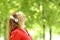 Woman wearing headphones meditating in a green park