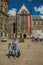 Woman wearing hijab headscarf and child walking in Amsterdam square.