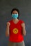 Woman wearing hygienic mask and wearing Kyrgyzstan flag colored shirt and standing with raised both fist on dark wall background