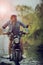 woman wearing jeans collection riding enduro motorcycle crossing shallow water track