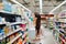 Woman wearing mask and gloves buying baby formula due to Covid-19 or Coronavirus and panic buying.Preparation for a pandemic