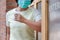 Woman wearing mask opening the door with the elbow for protection infection COVID-19