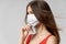 Woman wearing medical mask long hair red tank top side view