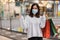 Woman wearing medical mask while shopping with bag at mall for prevention from coronavirus Covid-19 pandemic. new normal