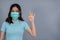 Woman wearing medical mask surgical mask and showing OK sign, virus protection