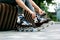 Woman wearing modern inline roller skates in park, closeup