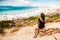 Woman wearing one piece swimming suit looking at sea from the cliffs. Woman enjoying summer and having a carefree holida