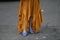 Woman wearing orange dress and purple open toe shoes