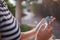 A woman wearing a protective mask looks at her smartphone display