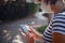 A woman wearing a protective mask looks at her smartphone display