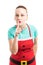 Woman wearing red Christmas apron making shush gesture