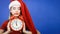 Woman wearing Santa Claus costume holding clock