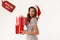 Woman wearing Santa hat holding Christmas gifts and tag with text Boxing day on white background