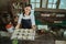 a woman wearing a smiling apron carries a baking sheet of several cookie cutters