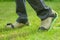 Woman wearing spiked lawn revitalizing aerating shoes, gardening concept