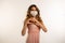 Woman wearing surgical mask shaping finger heart on a white background
