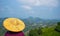 Woman wearing traditional chinese Asian hat looking at tea plantation