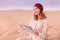 woman wearing turban reading map in Sahara desert in Africa. Travel and tourism concept