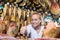 Woman wearing uniform working with jamon in meat shop