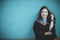 Woman wearing university graduation suit standing against clear blue wall toothy smiling face with happiness emotion